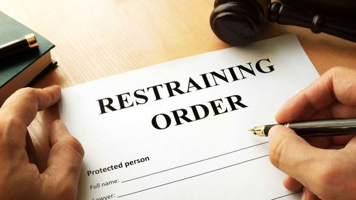 Close up of a hand signing a restraining order in Portland, Oregon.
